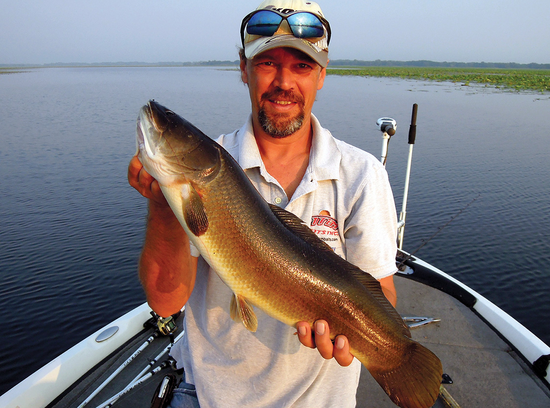 Tim Fey shows off a bowfin he caught. Photo by John N. Felsher
