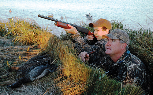 A young hunter waits until a more experienced hunter tells him to fire at ducks coming into range. Photo by John N. Felsher