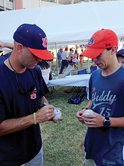 MLB pitcher Tim Hudson, a native of east Alabama, autographs a baseball for a young fan.
