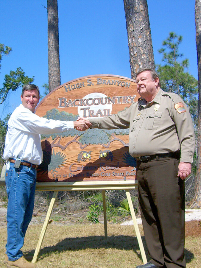Two men shaking hands by sign