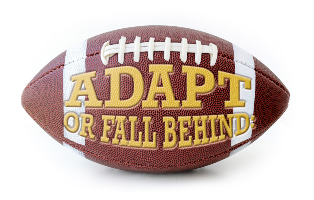 American Football decorated with the words "Adapt of Fall Behind" embossed.